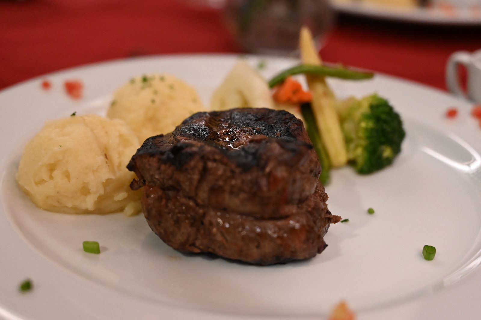 Seared fillet with mash and greens on a white plate